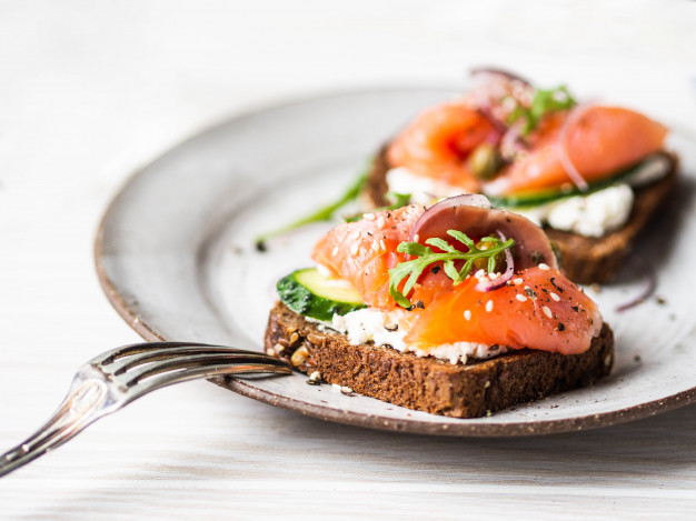 healthy-toasts-with-rye-bread-with-cream-cheese-salmon-fresh-cucumber-capers-sesame-seeds-black-pepper-arugula_86156-600